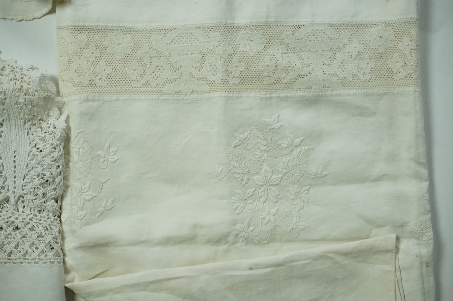 An unusual Victorian white linen hand worked table cloth. Embroidered along one edge, Wrought by L. Grover for her daughter Ethel Frances Burbury 1895. Together with three crochet edged cloths and a circular embroidered